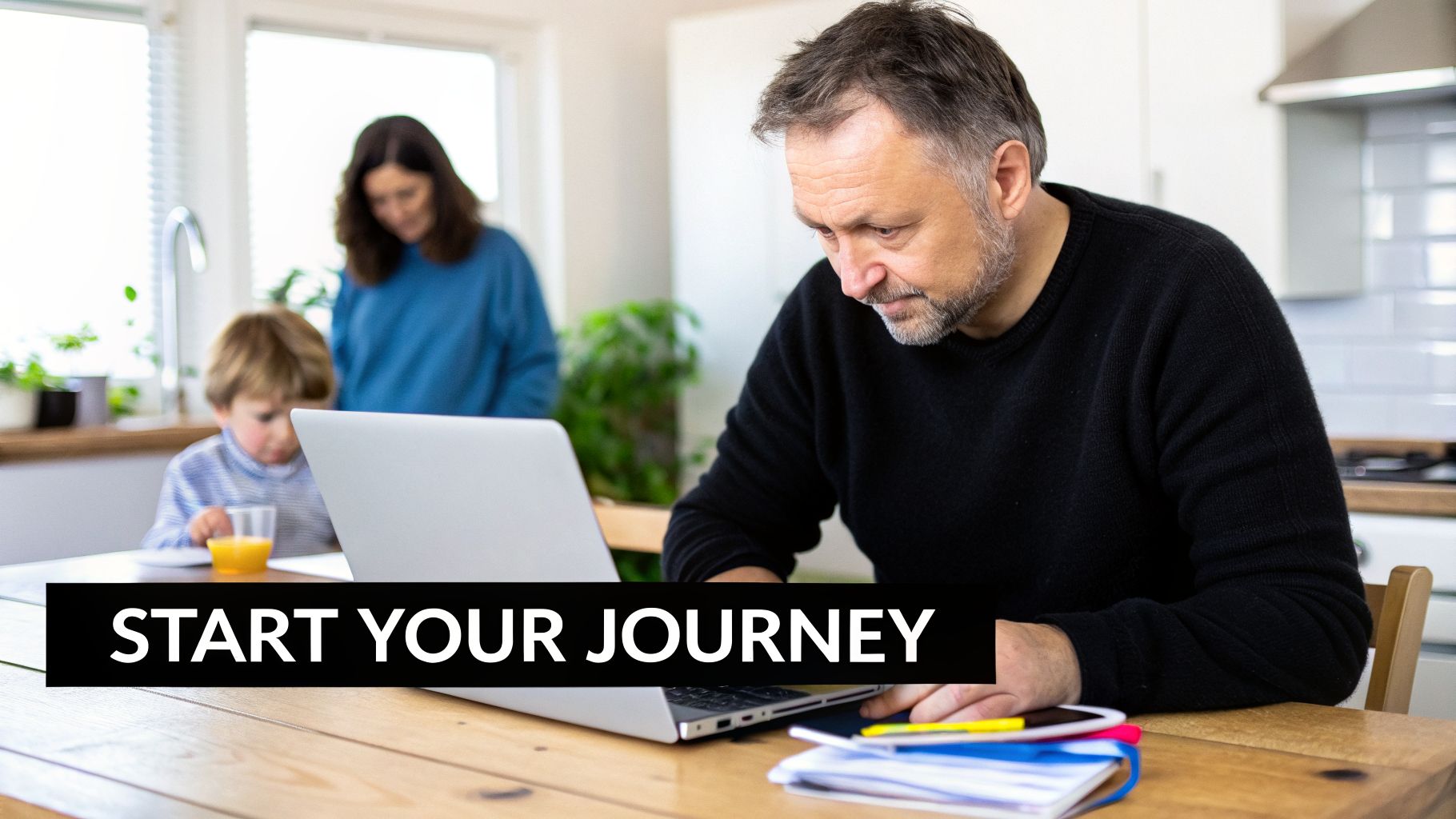 A man works on a laptop at a wooden kitchen table while his child drinks orange juice.