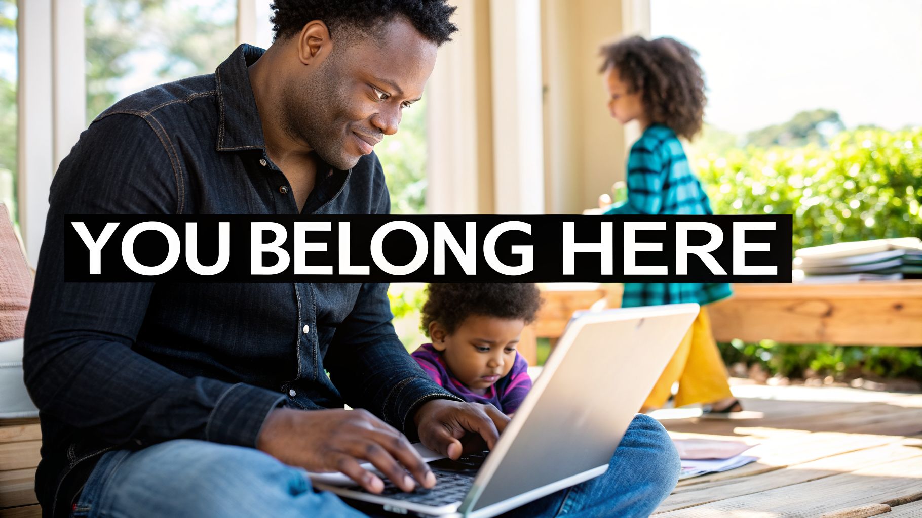 A Black man uses a laptop with children nearby on a sunny deck. Text: YOU BELONG HERE.