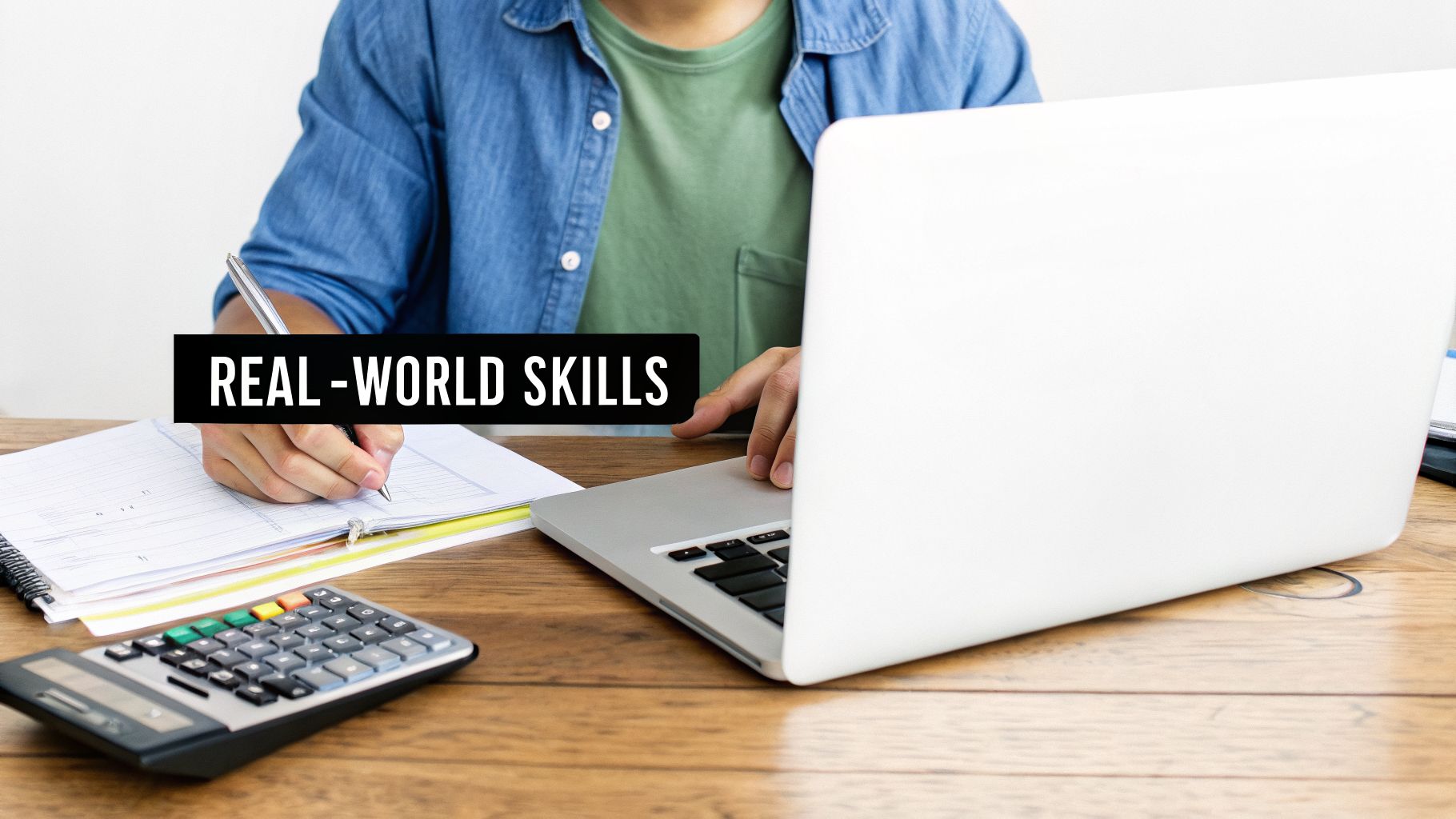 Person writing notes, using a laptop, and a calculator at a desk, with text 'REAL-WORLD SKILLS'.