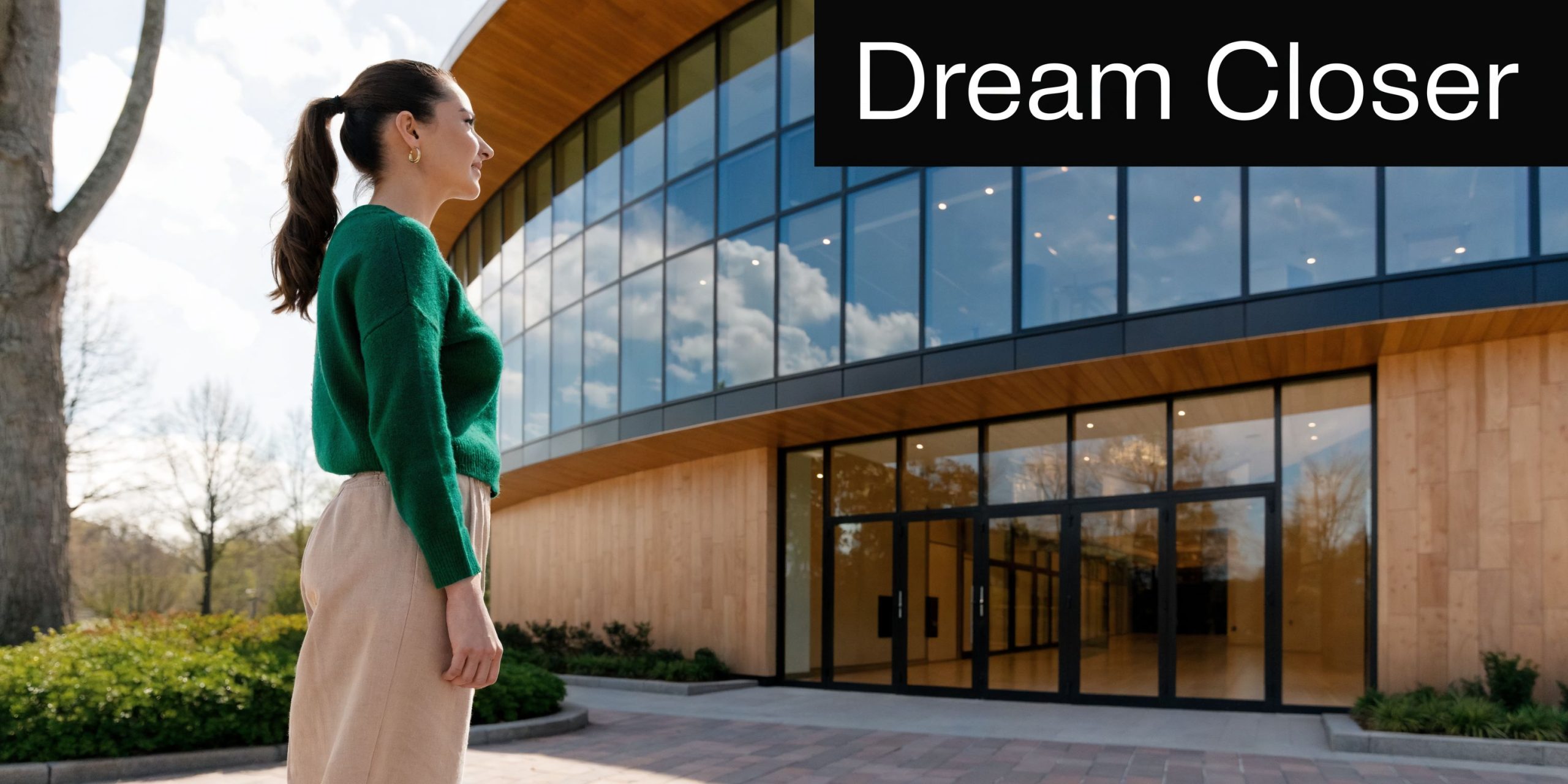A woman in a green sweater stands outside a modern university building, symbolizing access to higher education.