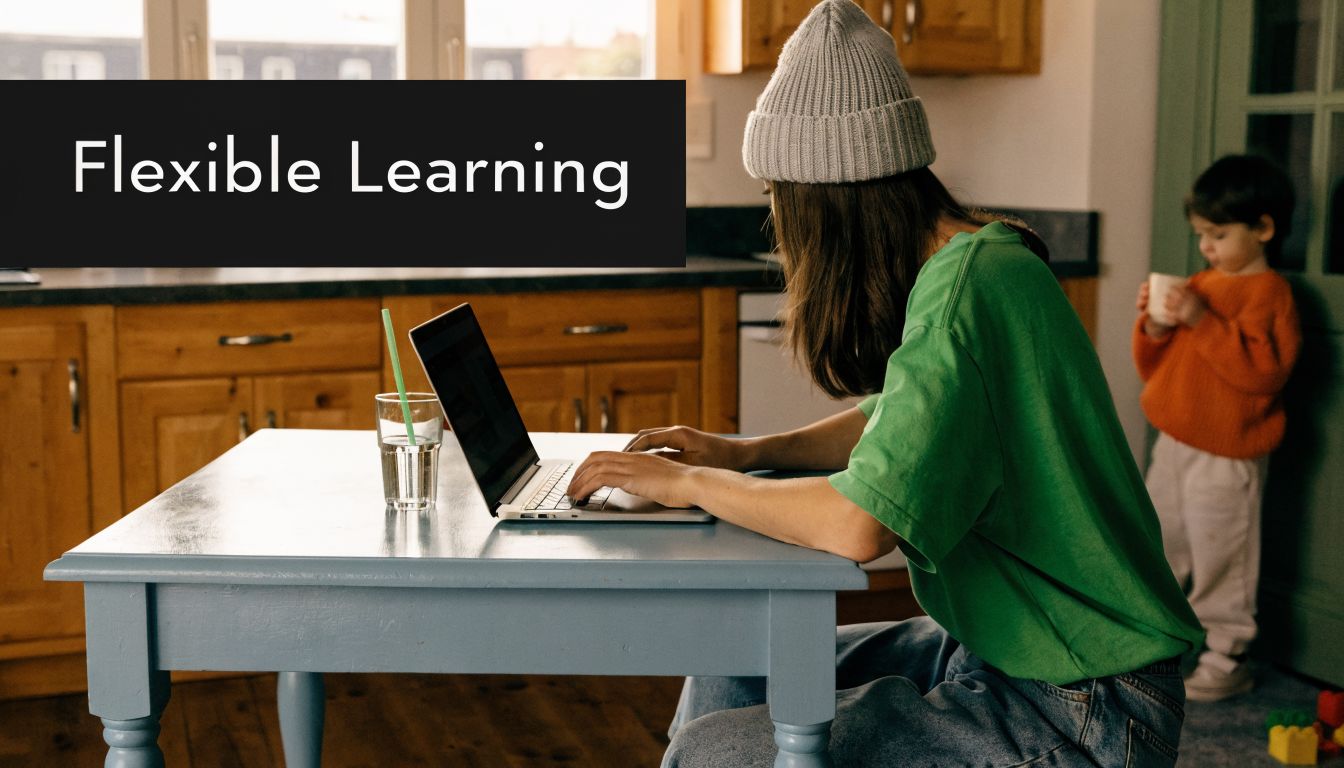 A woman wearing a beanie working on a laptop at a kitchen table while a child watches nearby.