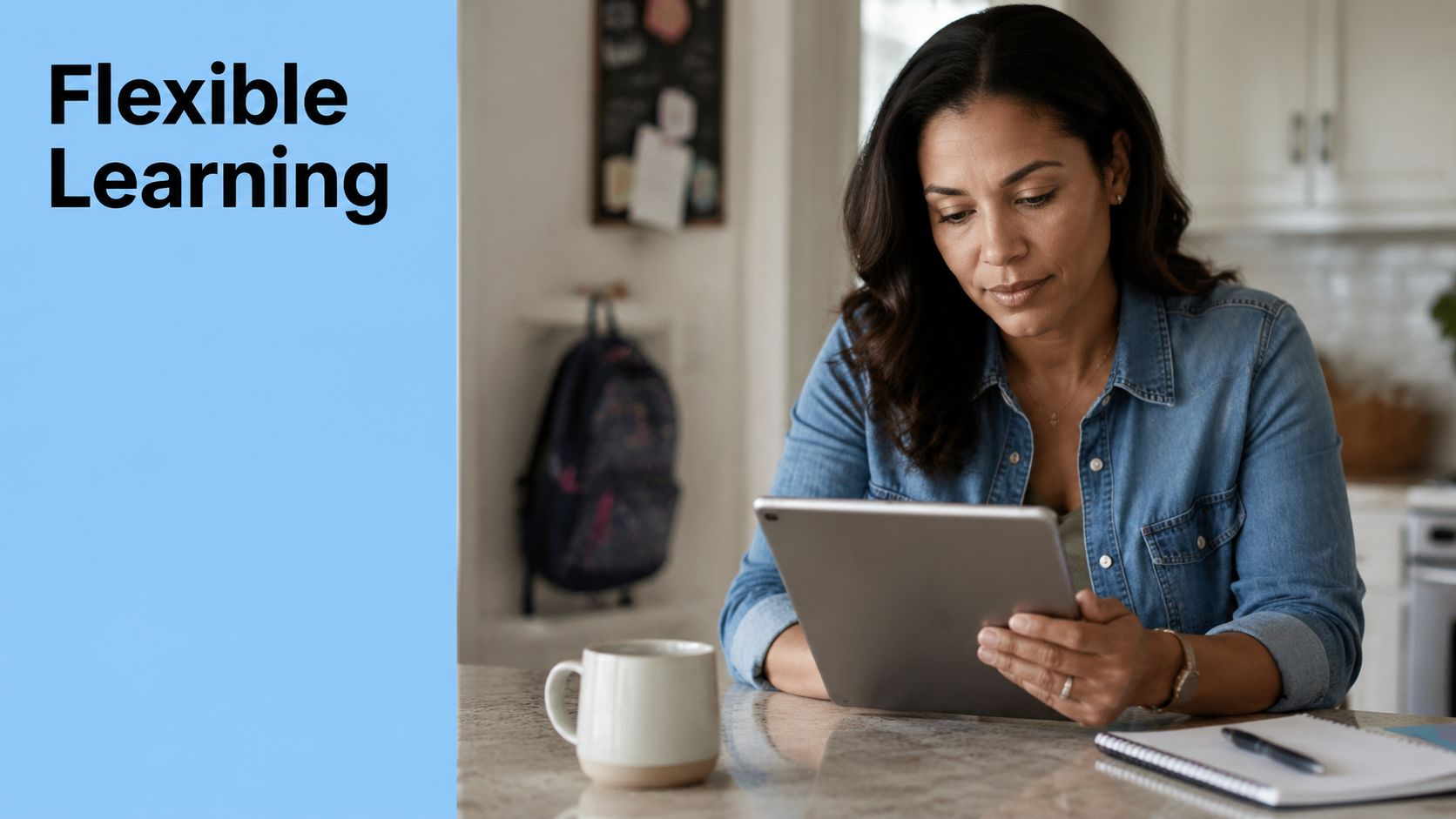 A woman wearing a denim shirt sits at a kitchen counter, focused on using a digital tablet.