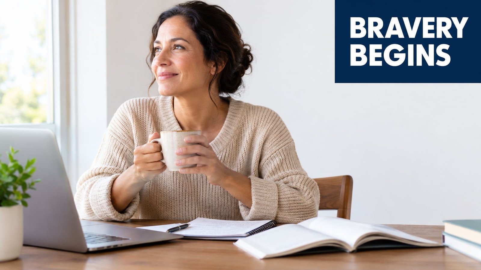 A woman holding a coffee mug while sitting at a desk with a laptop and open notebooks.